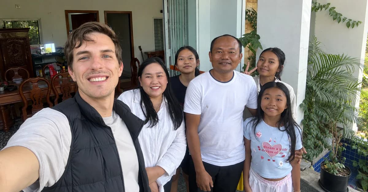 A traveller and a local family smiling together