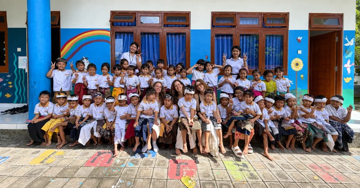 Volunteers, teachers and pupils gathered outside a school